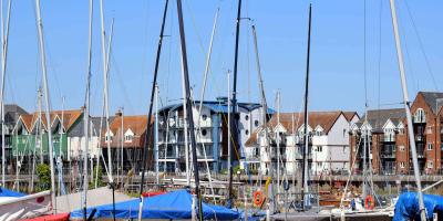 Harbour with boats surrounded by tall apartment buildings