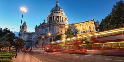 Buses driving past a historic building in London city centre