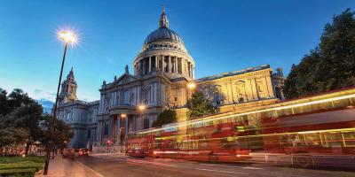 Buses driving past a historic building in London city centre