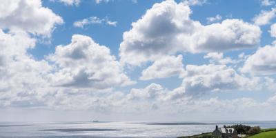 View across the sea from a grassy cliff