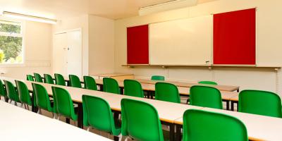 Room with white painted walls and rows of green plastic chairs