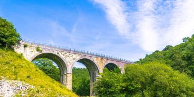 Viaduct bridge with trees and blue sky in the background