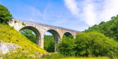 Viaduct bridge with trees and blue sky in the background