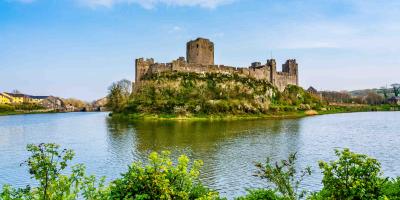 Pembroke Castle surrounded by a lake in Pembroke, Wales, UK