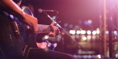 Person strumming a guitar