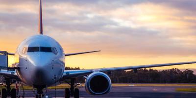 Commercial plane sitting on the runway at sunset