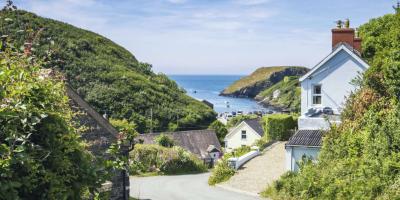 View onto the sea down a winding road with houses either side