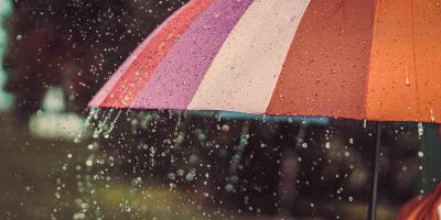 Raindrops falling on a colourful umbrella