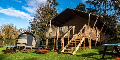 Safari tent and Landpod on a grass field