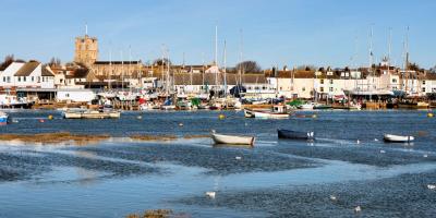 Busy coastal harbour with boats and white painted houses