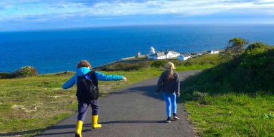 Two children walking near lighthouse