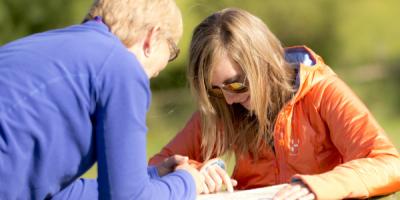 Two people looking at a map on picnic bench