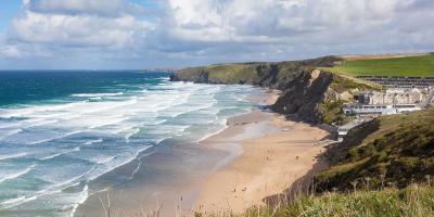 Grassy cliffs overlooking a sandy beach and blue ocean