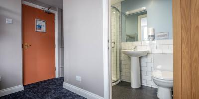 View into the en-suite bathroom with toilet, sink and shower