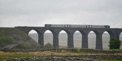 Train driving over a viaduct bridge in the countryside