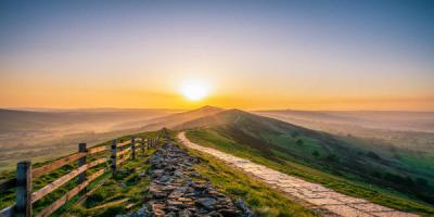 Stone footpath and wooden fence leading a long The Great Ridge in Castleton