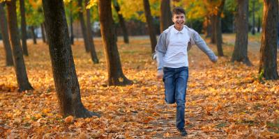 Boy running through autumnal forest