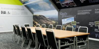 Meeting room at YHA South Downs with illustrations on the walls, large wooden table and chairs